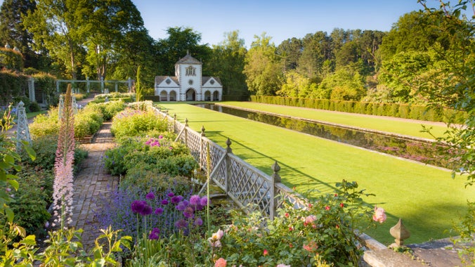The Lower Rose Terrace at Bodnant Garden, North Wales, photographed in early June. Beyond is the Canal Terrace with its lake and the Pin Mill. Planting includes roses and Alliums.